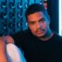 Stylish male portrait under neon blue lights in Buenos Aires, capturing a modern urban vibe.